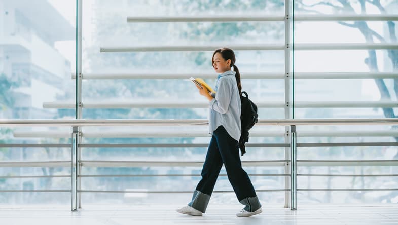 Student walking with a book